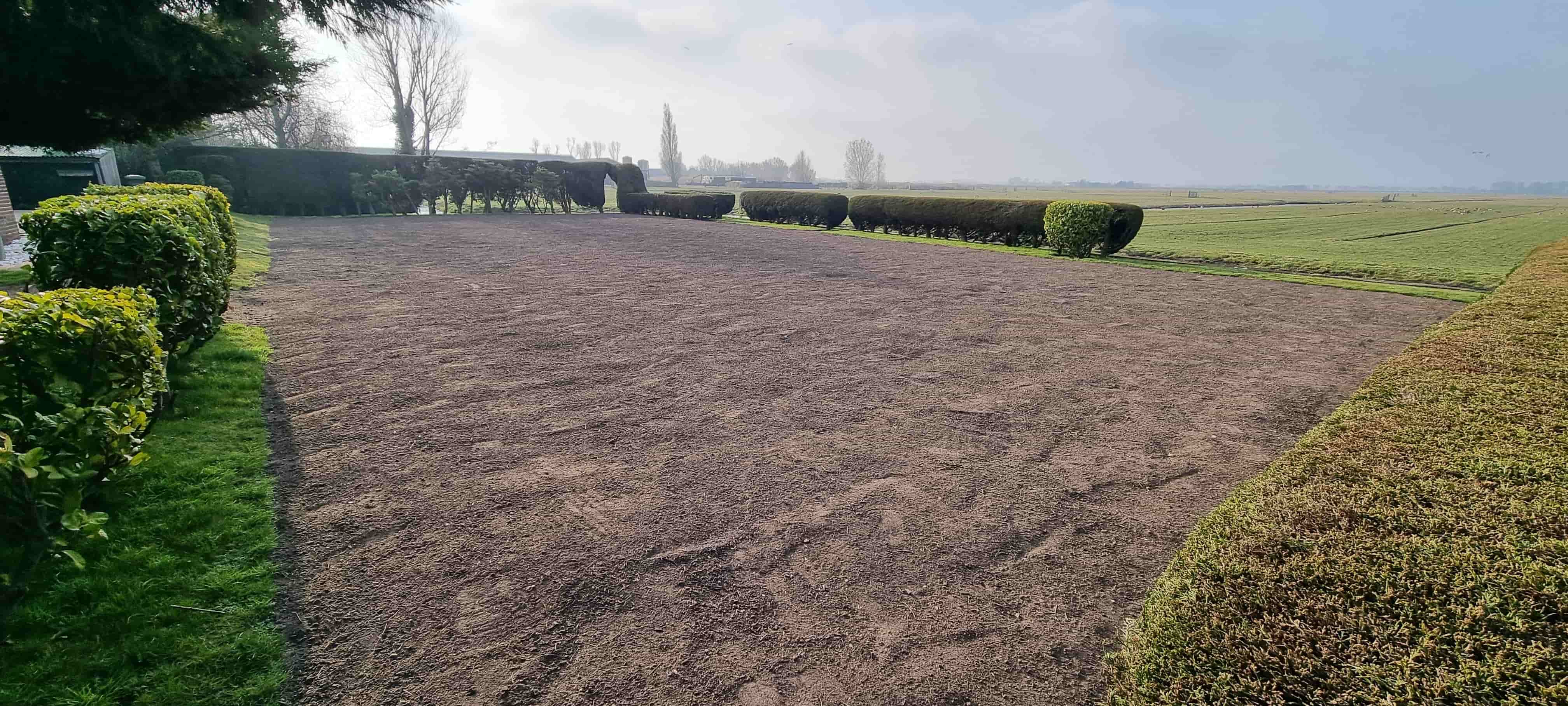 Oude grasmat verwijderen met een zodensnijder, de losgesneden stroken gras liggen klaar om op te rollen